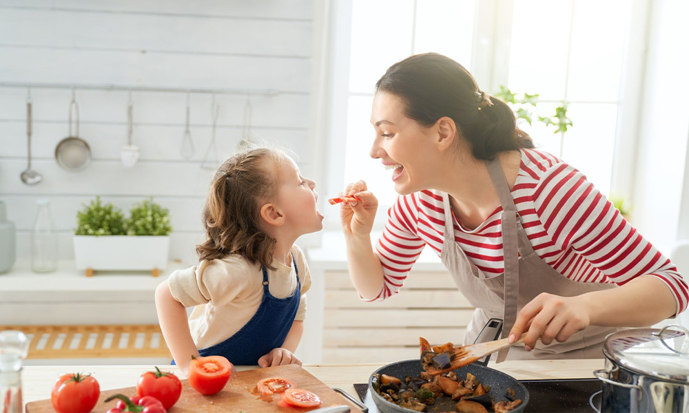 Mãe cozinhando com a filha